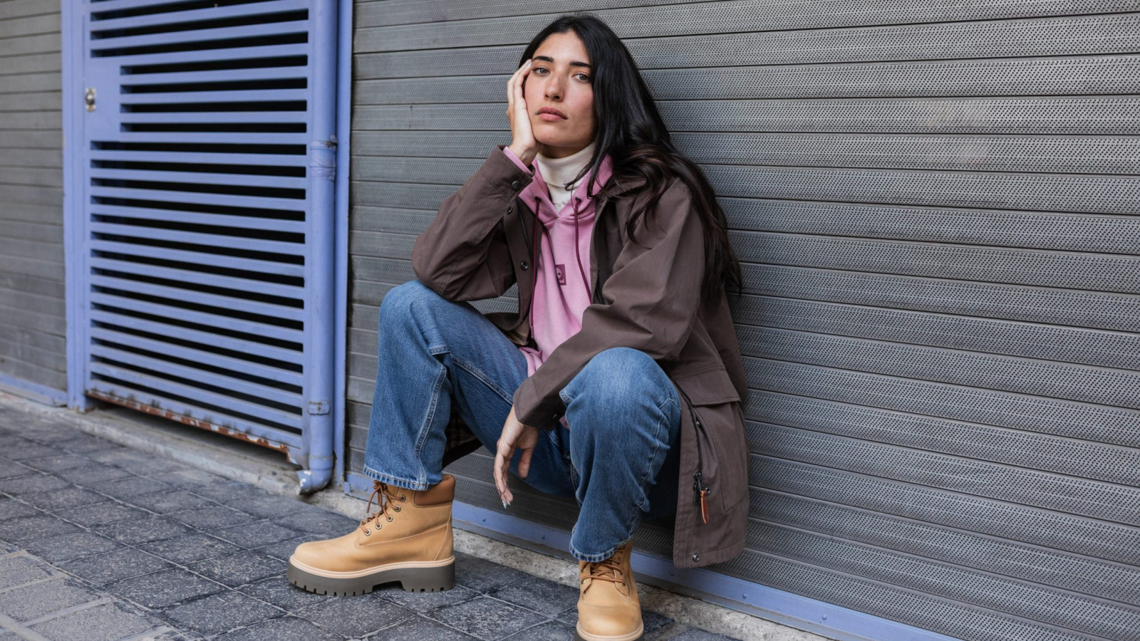 Mujer con outfit invernal urbano usando botas Timberland beige en entorno urbano