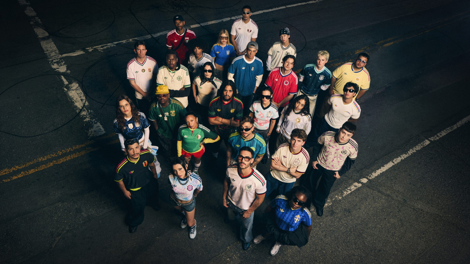 Grupo de modelos vistiendo equipaciones de visitante adidas de distintas selecciones nacionales en una calle urbana durante campaña previa al Mundial 2026.