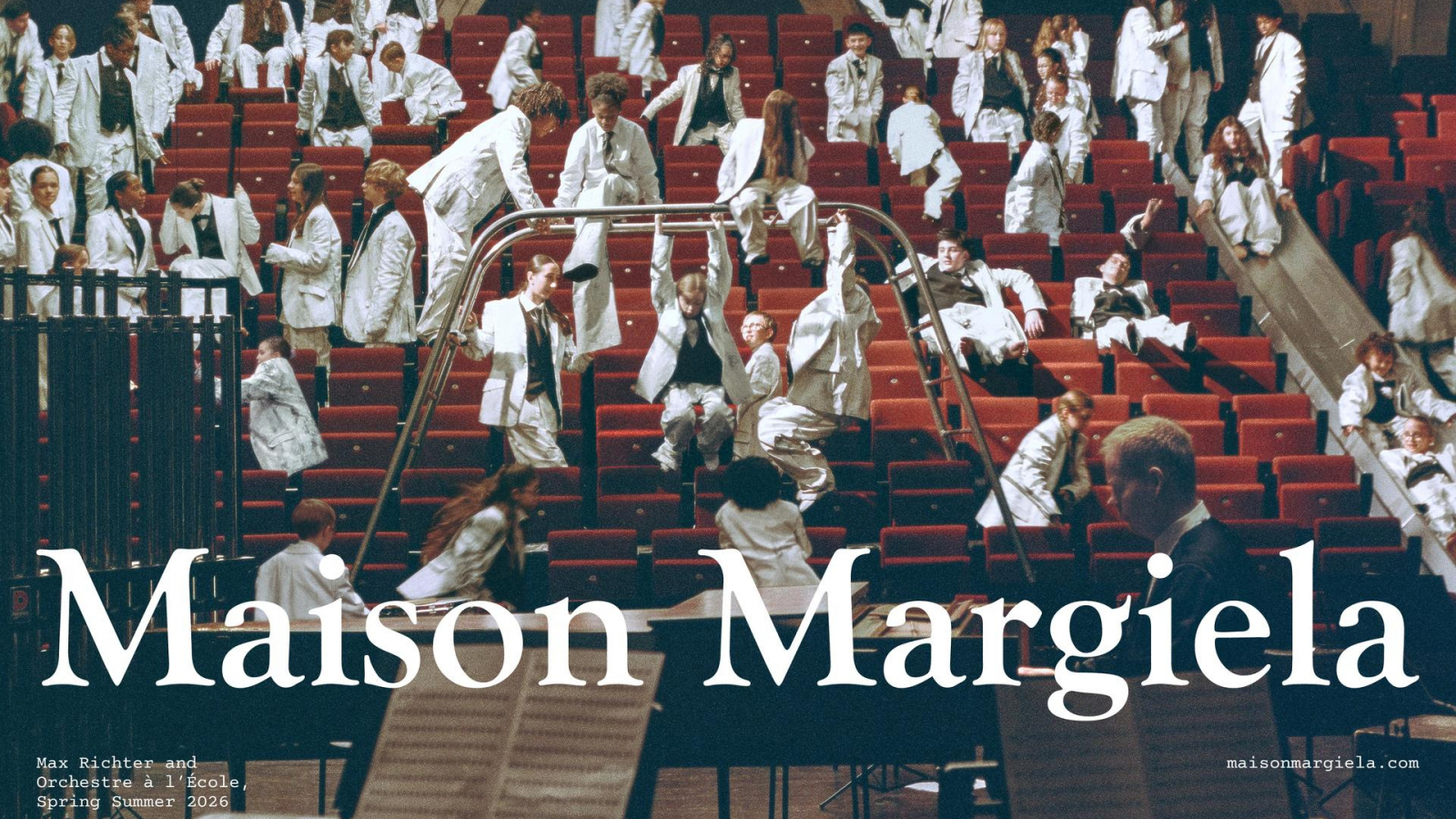 Jóvenes músicos de Orchestre à l’École con trajes blancos en un teatro durante la campaña Spring Summer 2026 de Maison Margiela con Max Richter.