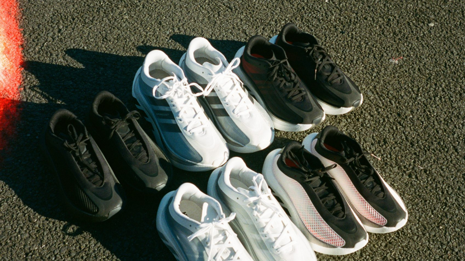 Diferentes versiones del adidas Originals HYPERBOOST EUPHORIA colocadas sobre una superficie de asfalto, mostrando las primeras combinaciones de color de la nueva silueta inspirada en el running.