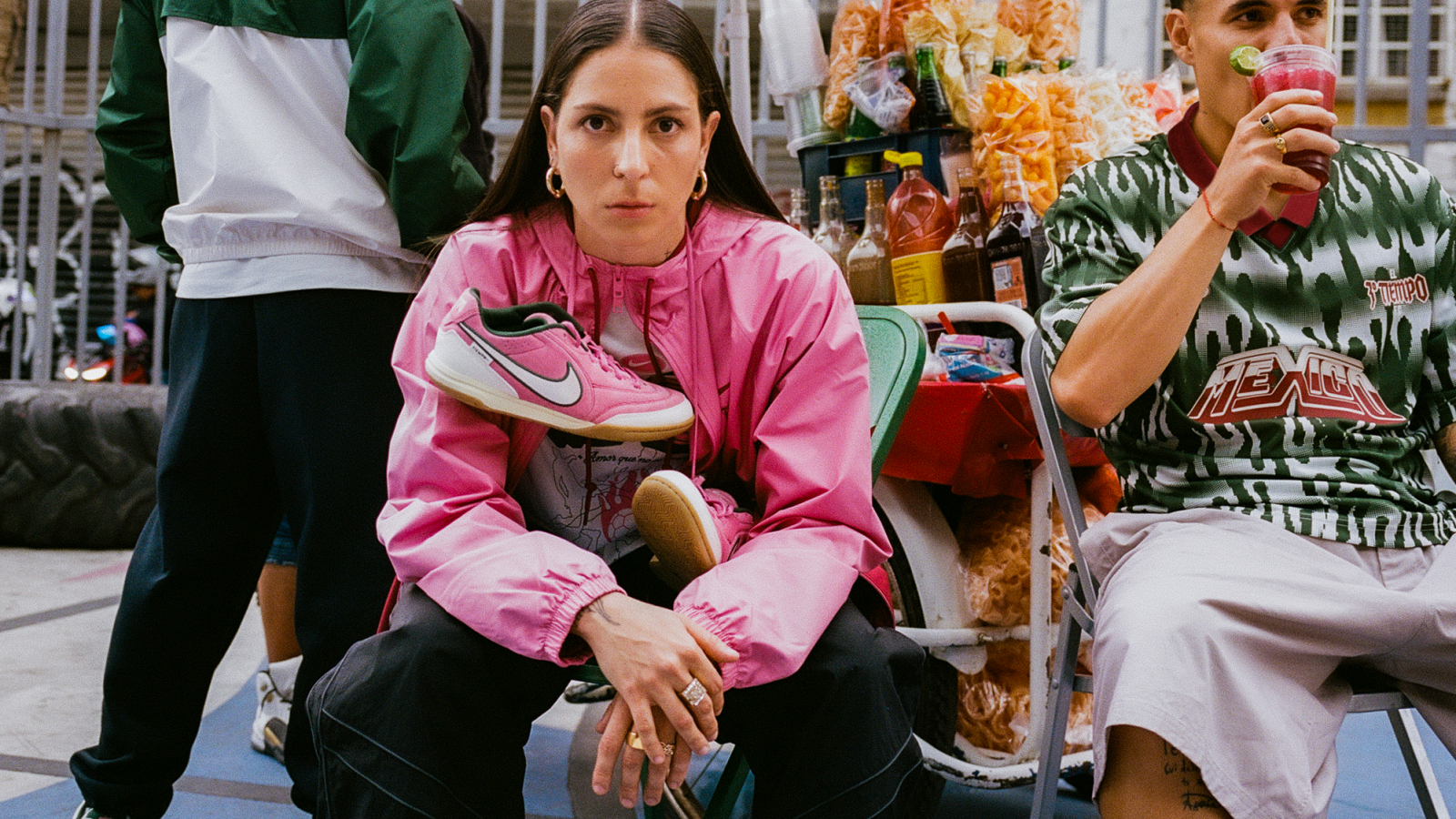 Personas usando piezas de la colección Nike Football “Tercer Tiempo F.C.” en un entorno urbano inspirado en la cultura de barrio y la convivencia alrededor del fútbol.